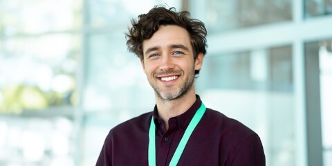Fototapeta premium Young man smiling while wearing badge in office lobby
