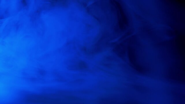 Vibrant blue smoke billows and swirls across a solid black background, creating a mysterious and ethereal visual effect. Concept of atmosphere, magic, mystery, and abstract visual effects.