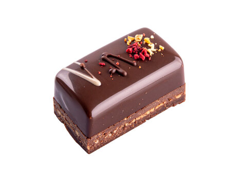 Chocolate ganache petit four with glossy finish and crumble garnish on dark chocolate layer