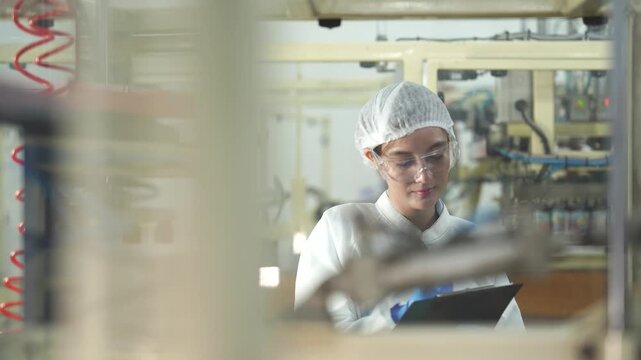 A female production engineer using AI-driven data and a digital clipboard to monitor automated manufacturing systems for optimal efficiency in a smart factory.