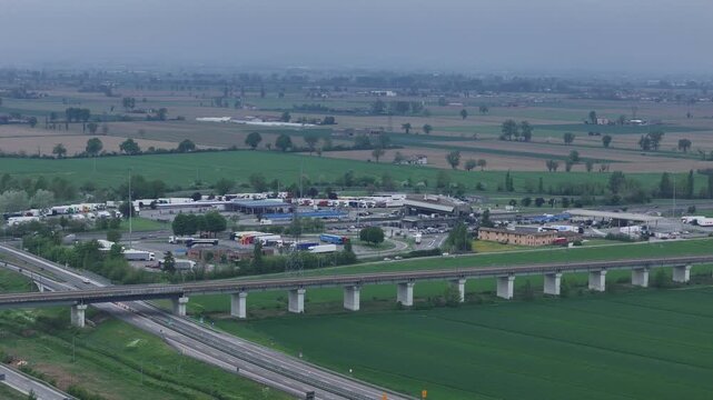 Autostrada A1 and A21 junction near Fiorenzuola d Arda Piacenza Emilia Romagna Italy with viaduct crossing farmland and connection to Via Emilia SS9 and toll area, drone telephoto