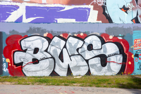 Warsaw, Masovian Voivodeship, Poland - April 17 2026: A vibrant piece of street art featuring a bold silver and white graffiti throw-up on a wall.