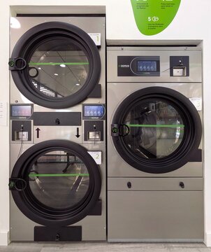 Lavander&iacute;a moderna autoservicio, con una hilera de puertas de secadoras industriales marca Domus Laundry, en Madrid, Espa&ntilde;a, 12 de marzo de 2026