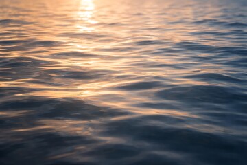 Close-up of rippling water reflecting the warm glow of the setting sun, creating a serene and tranquil natural scene with gentle waves and shimmering light. © muhagraph