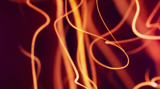 Bright orange glowing light scribbles crossing a dark red background