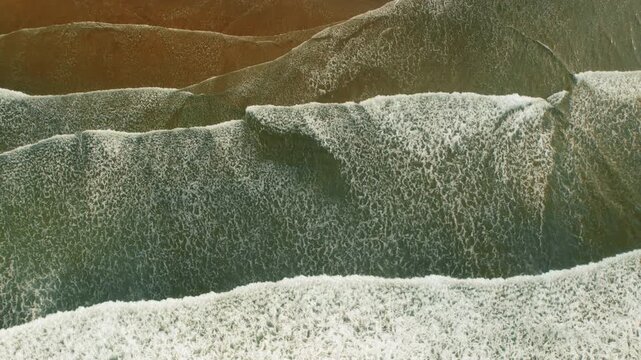 Foamy ocean waves rolling along sandy coastline in Costa Rica