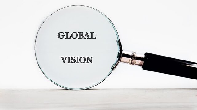 A magnifying glass slides over a white surface, gradually sharpening the distorted letters into the clear phrase Global Vision
