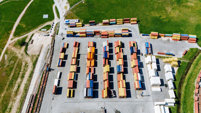 Aerial view of a vibrant tapestry of shipping containers arranged in neat rows under the sun, Sremska Mitrovica, Vojvodina, Serbia.