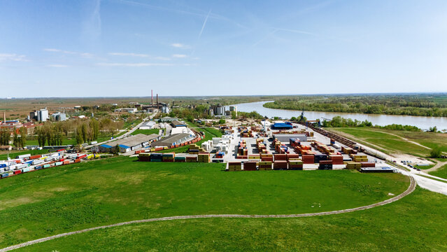 Aerial view of shipping containers clustered near the Sava River, with industrial buildings dotting the horizon, Sremska Mitrovica, Vojvodina, Serbia.