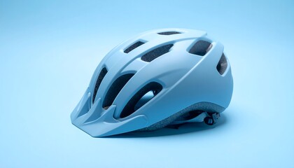 Fototapeta premium Light blue bicycle helmet on a gradient blue background