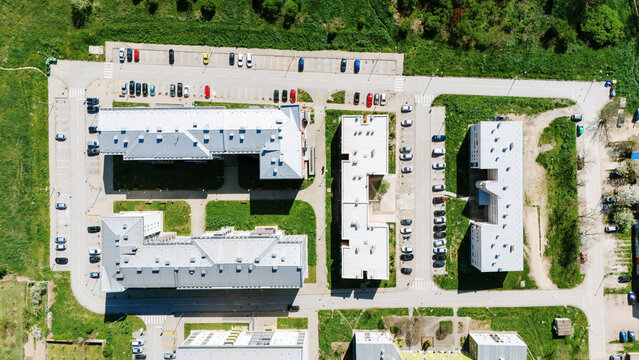 Aerial view of stark white buildings contrast with the vivid green lawns and dark asphalt roads, creating a structured yet serene urban landscape, Sremska Mitrovica, Vojvodina, Serbia.
