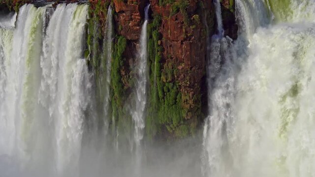 Powerful waterfalls cascading over red cliffs at Iguazu Falls, Argentina