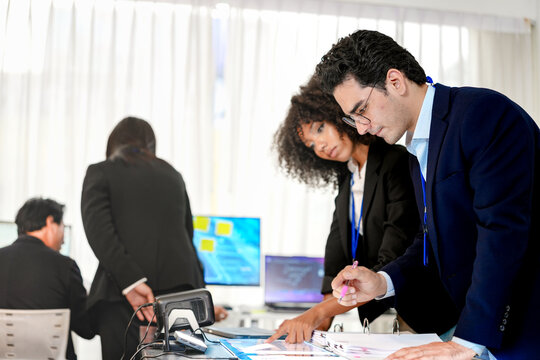Serious DevSecOps squad collaborating on cloud native security protocols. Diverse IT professionals evaluating privacy preserving AI models and technical paperwork at a tech command center.