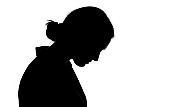 Silhouette profile portrait of a young woman looking down in contemplation