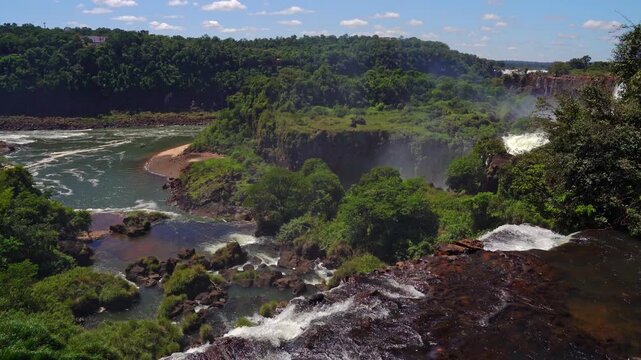 Scenic view of Iguazu Falls in Argentina, powerful waterfalls surrounded by lush tropical rainforest and green jungle landscape