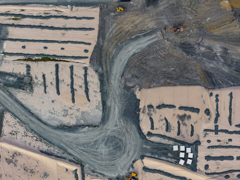 Aerial view of a construction site with excavators working on earthworks and prepared ground Pomarance, Tuscany, Italy.