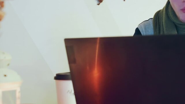 Caucasian man focused on laptop screen glow with intent expression, sipping from mug, lantern light and reflective monitor, typing and reading code or notes during late study session, concentrated