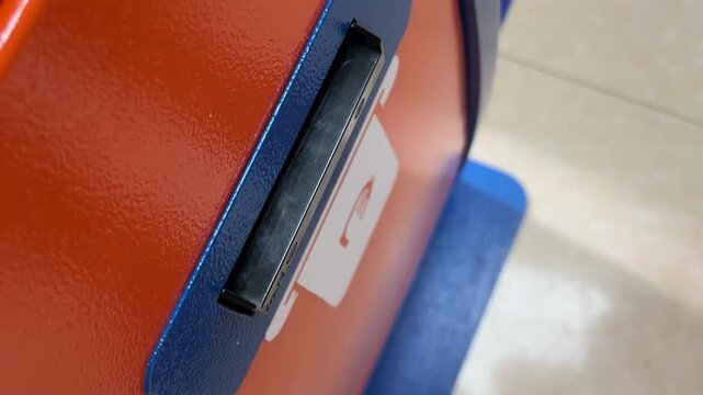 Horizontal video close up. Male hand puts paper purple banknote 100 GEL in orange blue ATM with symbol of Georgian currency. Cash money. One hundred lari. Concept of pay loan, salary, bribe, tax