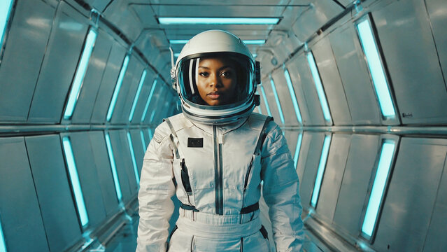 Female astronaut in futuristic spacesuit walking in spacecraft corridor science technology space exploration and future concept portrait