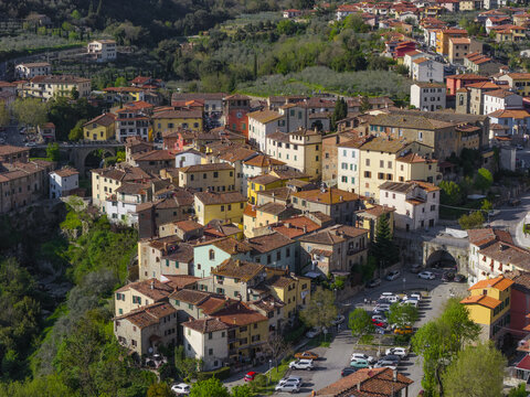Aerial view of the historic village of Loro Ciuffenna with its traditional terracotta rooftops, stone architecture, and ancient bridge over a deep gorge in Loro Ciuffenna, Tuscany, Italy.