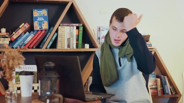 Busy white freelancer with laptop phone, juggling calls and typing while sipping coffee, bookshelf backdrop and desk setup, home workspace energy with focused deadline drive, hands on keyboard