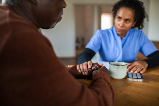 Nurse comforting senior patient during home care visit