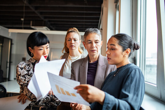 Businesswomen collaborating over reports in office