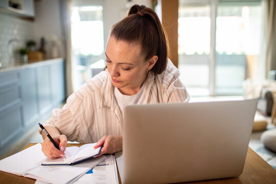 Young woman budgeting at home kitchen table