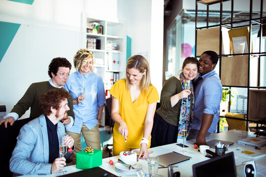 Coworkers celebrating birthday in modern office