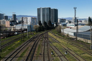 Obraz premium Urban railway tracks leading toward modern city skyline