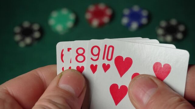 Player's hand displays a sequence of playing cards straight flush featuring hearts numbered ten to six, while colorful poker chips are arranged in the background on a green felt table