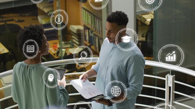 Man walking to railing opening binder while woman showing tablet tech icons marking business review