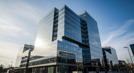 Obraz premium Modern Glass Office Building Reflecting the Sky on a Sunny Day.