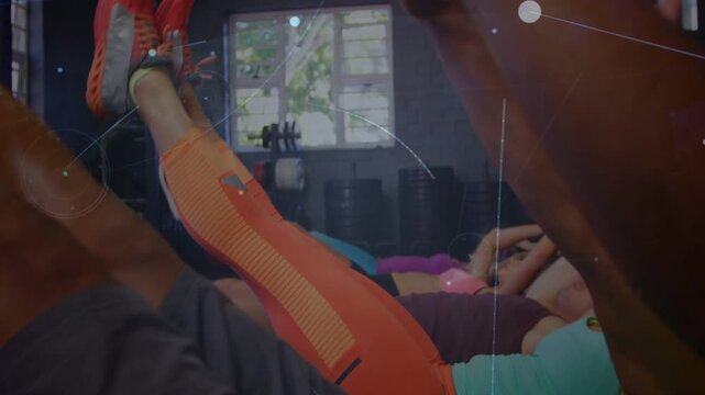 Participants on cue performing fitness V-sit crunches on mats, digital overlays floating over group