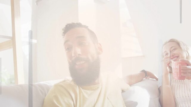 Bearded man leading group chat on couch, camera pushing, flare scanline washing mugs for marketing