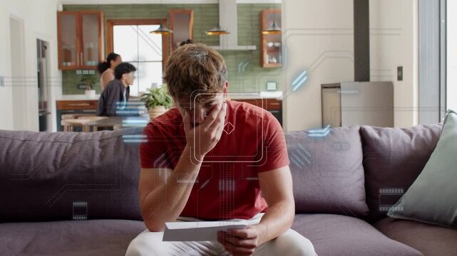 Man entering with mail, sitting on couch checking bills while finance graphics appearing around him