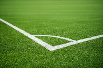 Fototapeta premium Soccer Field Corner: An elevated perspective captures the pristine corner of a soccer field, showcasing the verdant green grass and the crisp white lines that define the playing area.