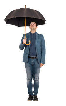 Full length portrait of confused businessman standing under open umbrella looking up perplexed isolated on transparent background