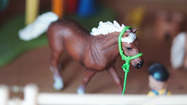 A small toy horse holding a green rope in its mouth, ideal for illustrations and designs