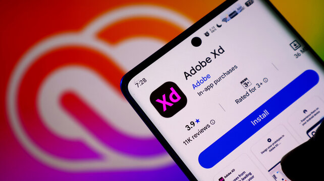 Closeup of a smartphone screen displaying the adobe xd app page on the google play store
