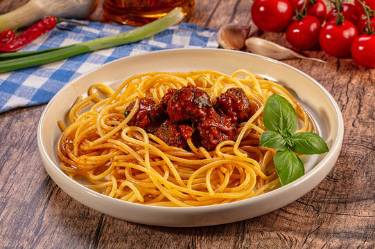 Delicious spaghetti meatballs fresh basil wooden table background, Italian cuisine