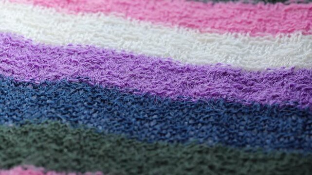 A close-up shot of a vibrant multicolored knitted blanket, perfect for use in textiles or craft projects