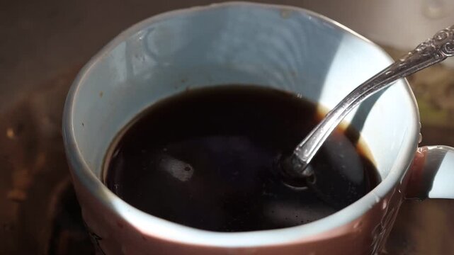 A cup of coffee with a spoon sitting inside