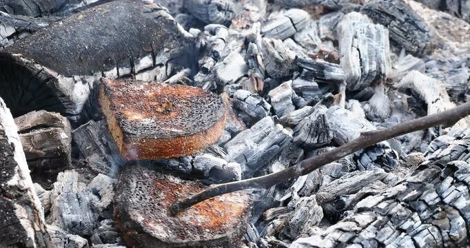 pieces of bread are fried on coals