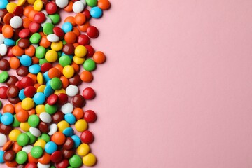 Obraz premium Delicious colorful candies on pink background, top view. Space for text