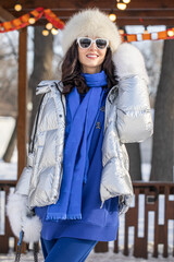 Obraz premium Winter portrait of a young beautiful woman in a down jacket