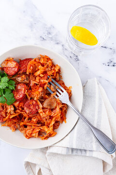 Bigos, Polish dish bigos, on a marble table, stewed meat with cabbage, chorizo sausages, mushrooms, homemade, without people,
