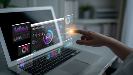 Futuristic Data Analytics Visualization with Interactive Touch Interface on Laptop Screen in Modern...