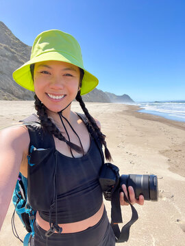 UGC photographer smiling holding camera  Selfie at beach