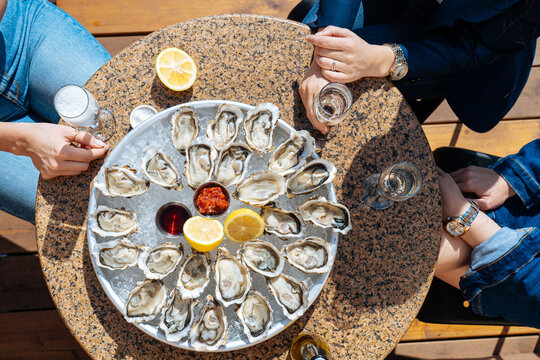 Group of People Sitting Around Table With Oysters